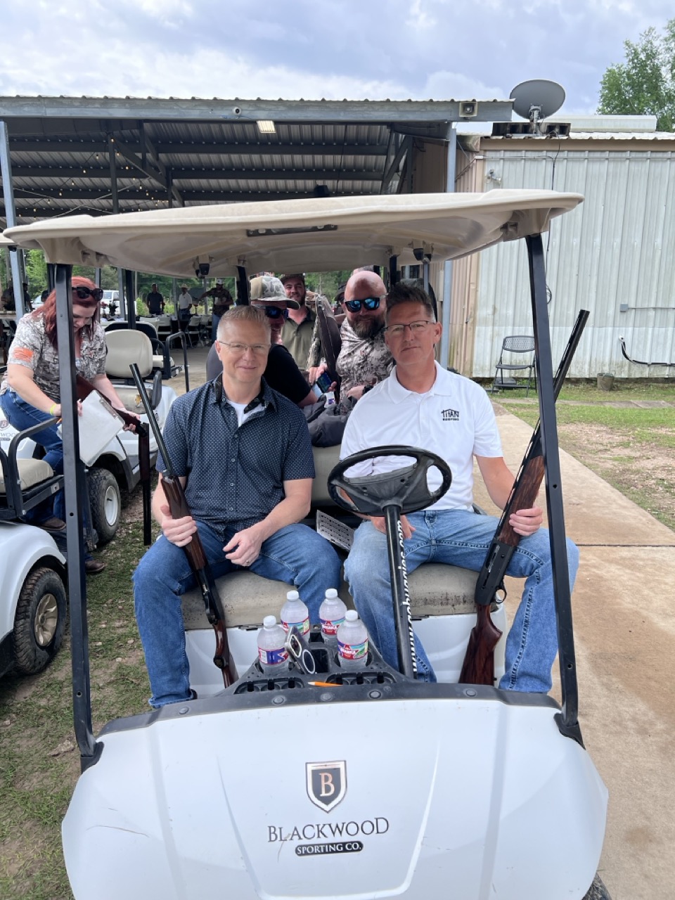Ed and Greg Brogdon Titan Roofing owners in golf cart at skeet shoot